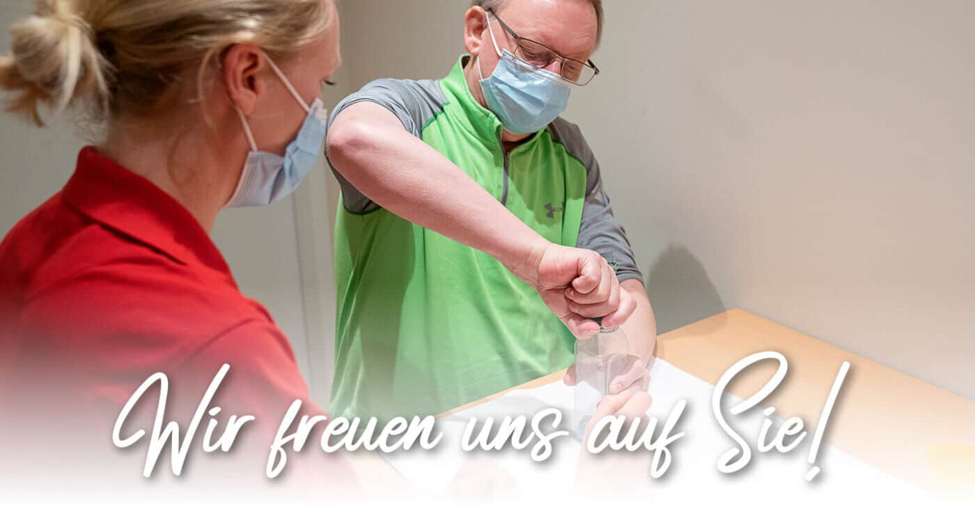 Therapeut bei Ergophysica bei einer Behandlung, Maskenpflicht.